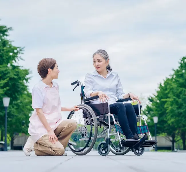 caregiver talking with woman in wheelchair park