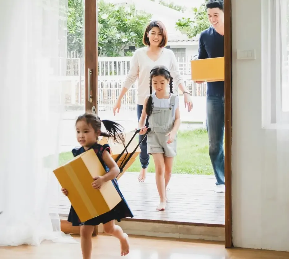 family moving into home carrying boxes