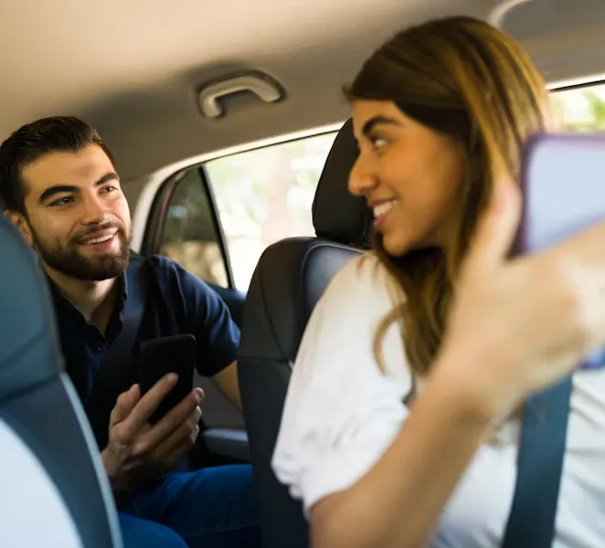 friends sharing smartphone in car ride