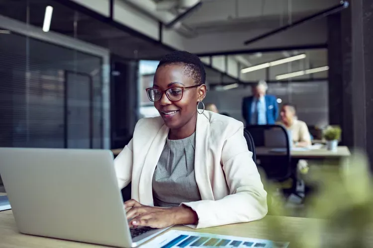 smiling professional working laptop open plan office